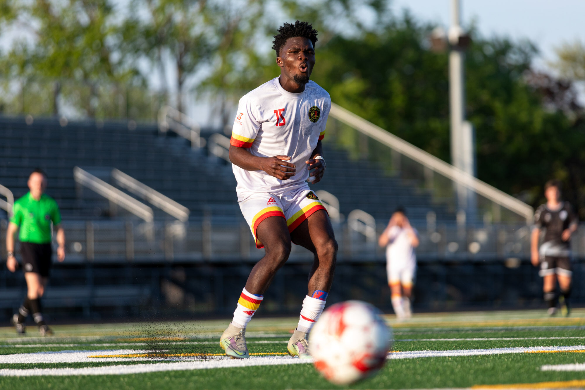 A player wearing 15 on a white kit is shown with his lips pursed in frustration. 