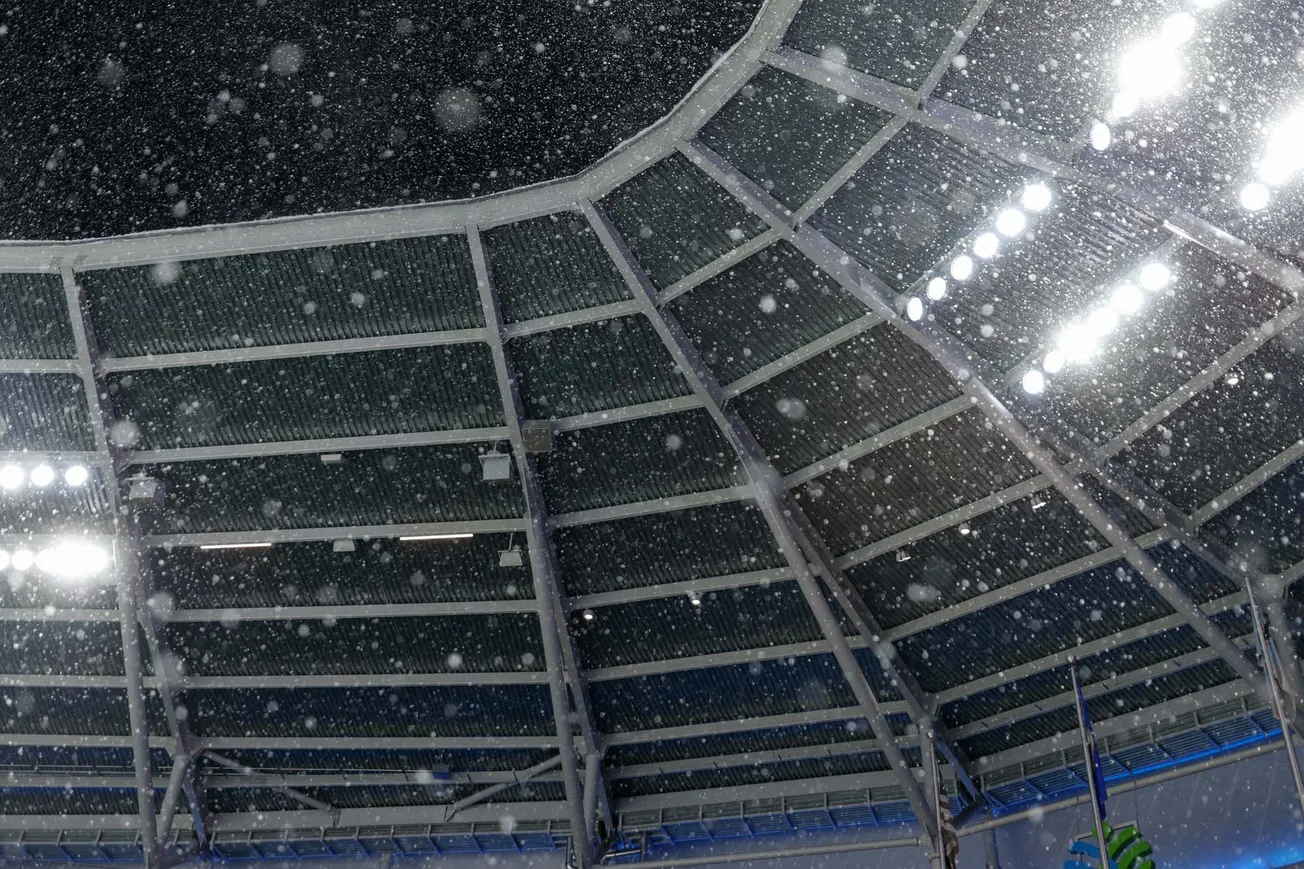 Snow falls from the sky and passes by the stadium lights and drops into Allianz Field.