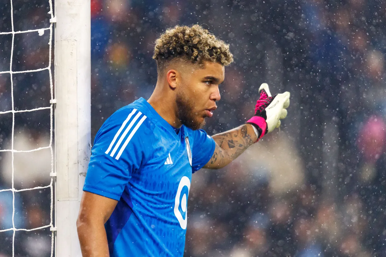 Snow falls as St. Clair points in the direction the wall should move.