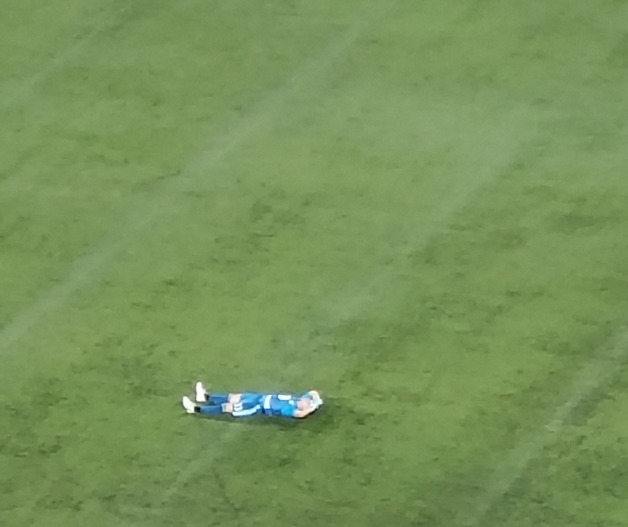Bobby Shuttleworth, wearing the blue MNUFC keeper kit from 2018, lies on his back on the turf at TCF Bank Stadium, staring at the sky
